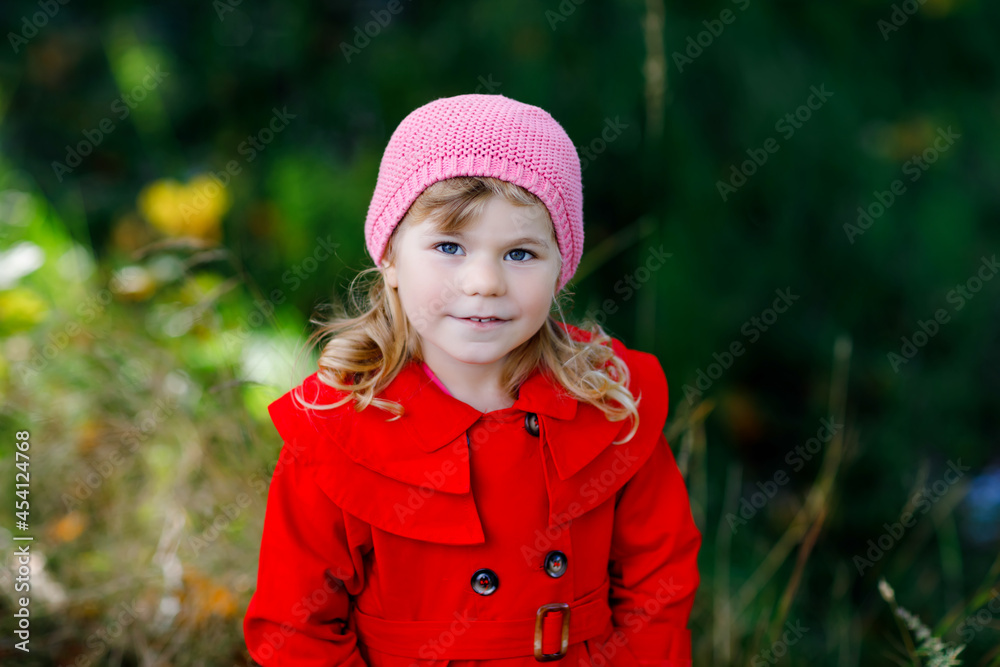 Cute little toddler girl in red coat making a walk through autumn forest. Happy healthy baby enjoying walking with parents. Sunny fall day with child. Active leisure and activity with kids in nature. Cute little toddler girl in red coat making a walk through autumn forest. Happy healthy baby enjoying walking with parents. Sunny fall day with child. Active leisure and activity with kids in nature.