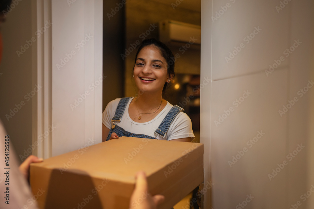 Young woman accepting delivery package at the doorstep. Young woman accepting delivery package at the doorstep.