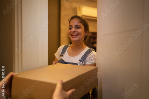 Young woman accepting delivery package at the doorstep. photo