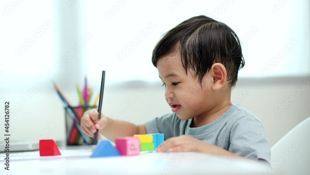 Asian little boy education from home. Developing children's learning before entering kindergarten Practice the skills of playing with wooden toys and drawing and painting.
Asian little boy education from home. Developing children's learning before entering kindergarten Practice the skills of playing with wooden toys and drawing and painting.