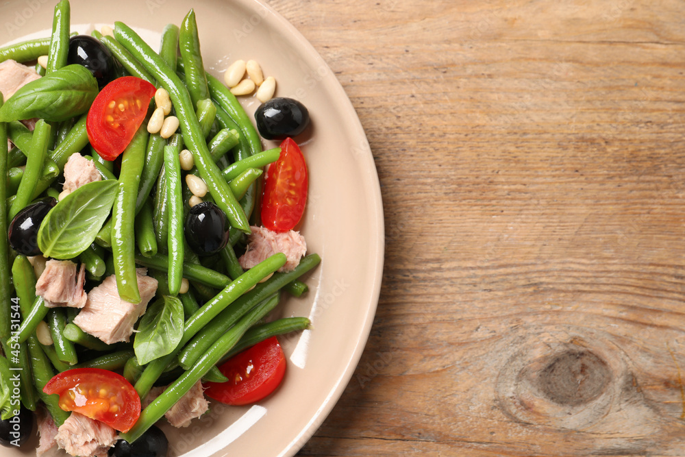 Plate of tasty salad with green beans on wooden table, top view. Space for text Plate of tasty salad with green beans on wooden table, top view. Space for text