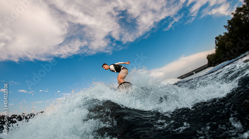 active man with an amputated hand ride the wave on wakeboard © fesenko