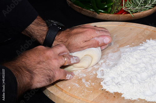 Pizza maker's hands kneading the dough. The cook makes pizza.