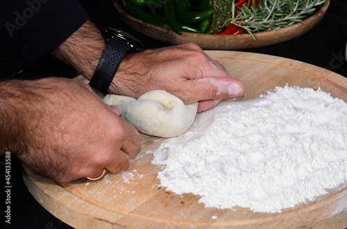 Pizza maker's hands kneading the dough. The cook makes pizza.