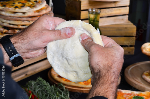Pizza maker's hands kneading the dough. The cook makes pizza.