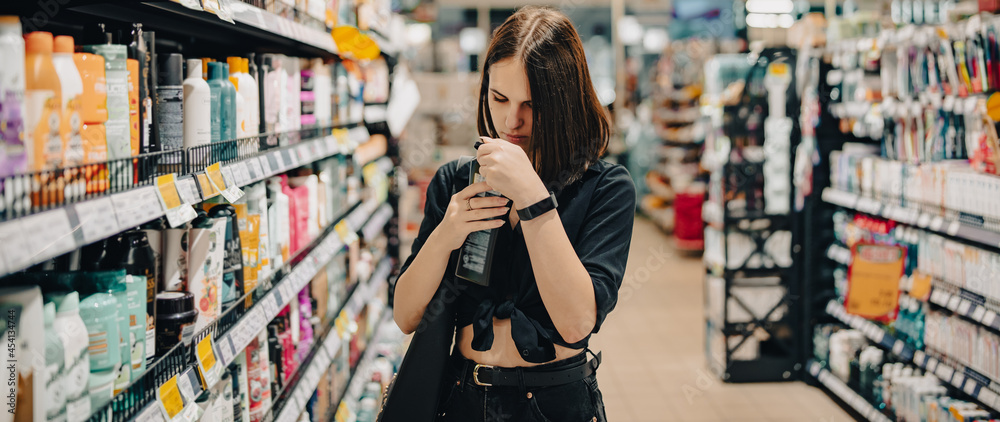 Young woman choosing care cosmetic in a supermarket. shopping