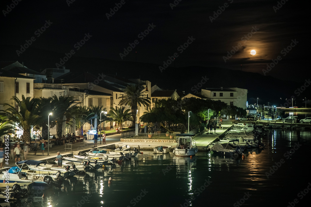 Nabrzeże portowe wieczorową porą oświetlone księżycem na wyspie Pag, Chorwacja - obrazy, fototapety, plakaty 