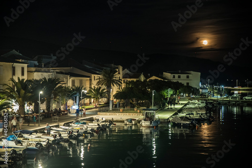 Nabrzeże portowe wieczorową porą oświetlone księżycem na wyspie Pag, Chorwacja photo