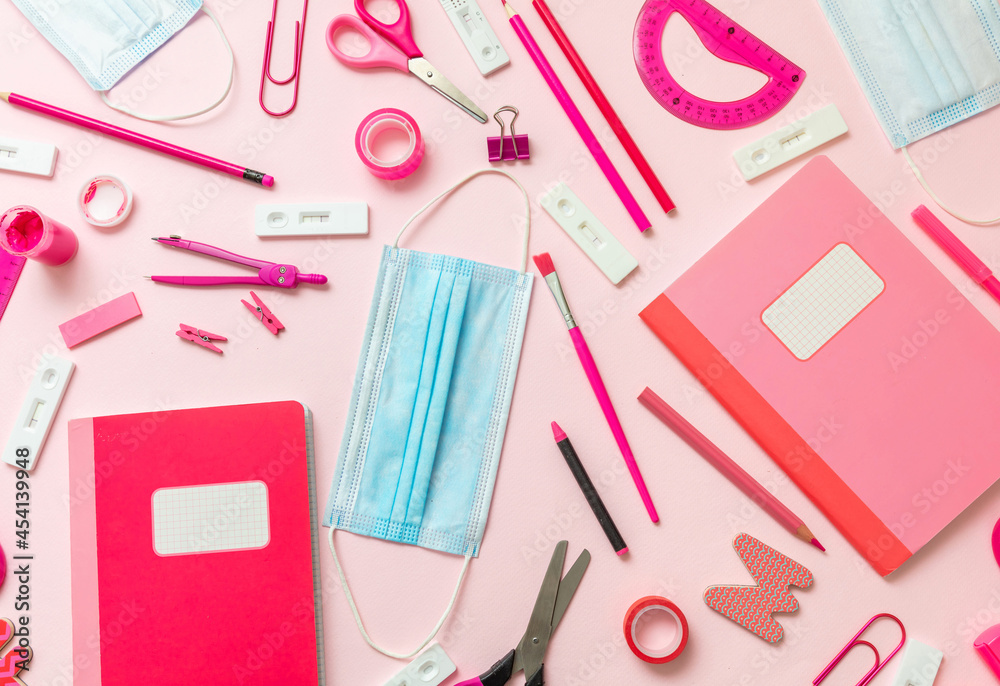 Back to school Covid 19 days. School supplies and Coronavirus measures flat lay. Rapid test, protective medical mask and stationery on pink background Back to school Covid 19 days. School supplies and Coronavirus measures flat lay. Rapid test, protective medical mask and stationery on pink background