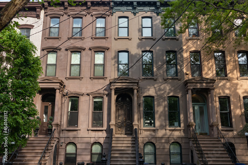 Row of Beautiful Old Brownstone Homes with Staircases along an Empty Sidewalk in Jersey City New Jersey