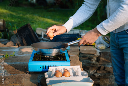 Person cooking egg on camping stove