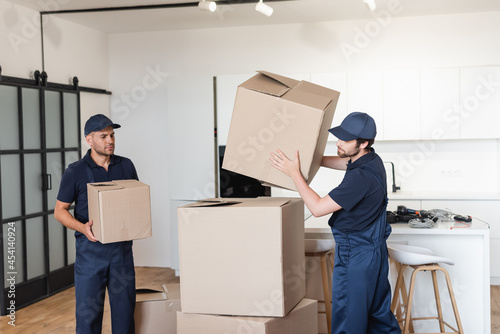 workers in uniform stacking carton packages in kitchen © LIGHTFIELD STUDIOS
