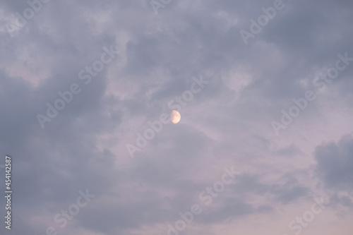Half moon behind dappled cloud