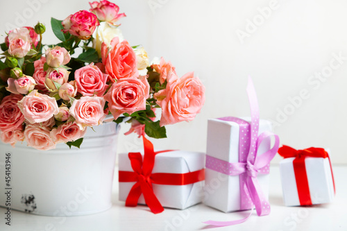 Bouquet of pink roses and boxes with gifts