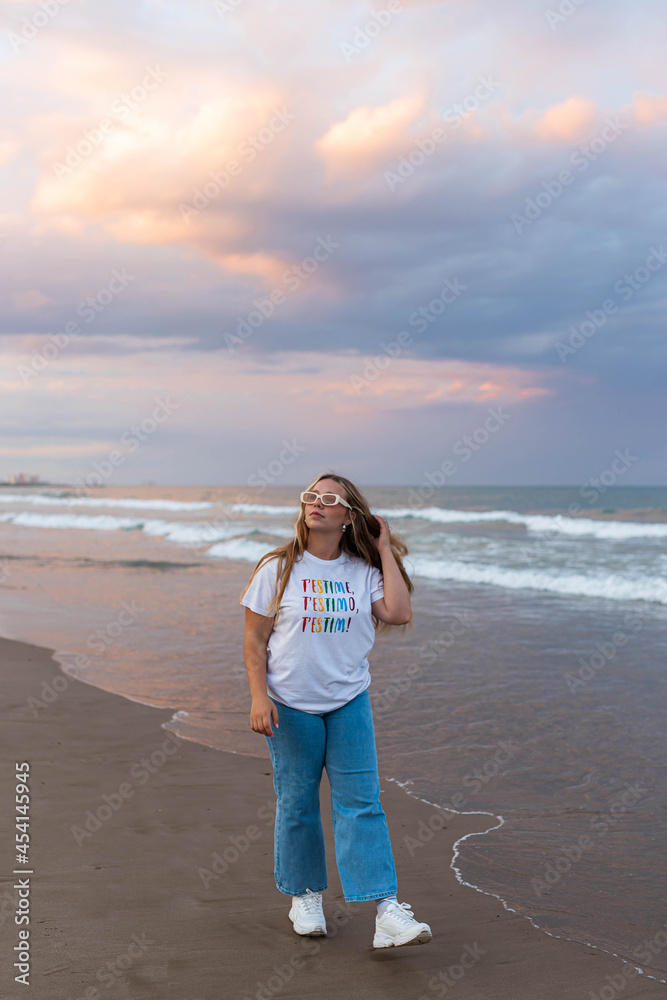 Content stylish woman walking on beach in sunset Content stylish woman walking on beach in sunset