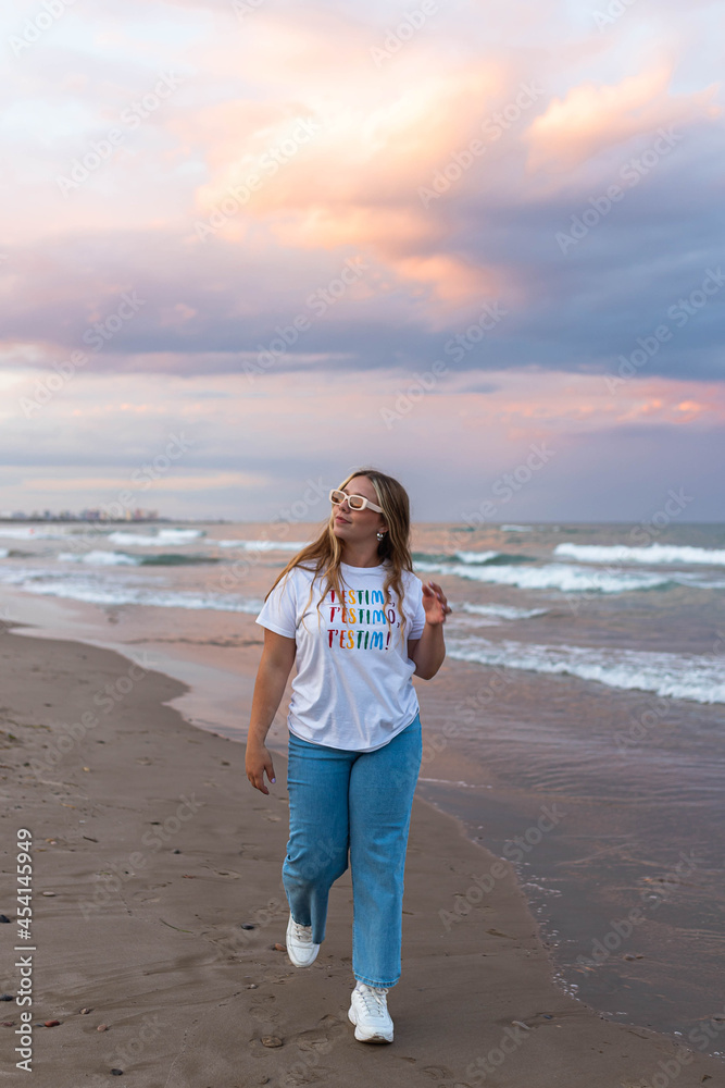 Content stylish woman walking on beach in sunset Content stylish woman walking on beach in sunset