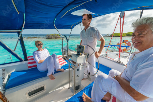 Senior couple and young man, family, enjoying sailing trip on a luxury summer holiday vacation, sunny weather and ocean in background, love and romance on a beautiful yacht © TRAVEL EASY