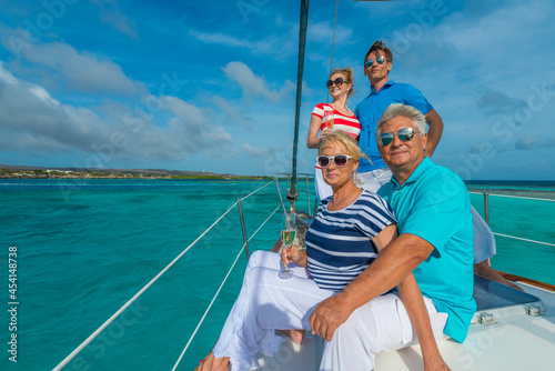 Senior and young couples, family, enjoying sailing trip on a luxury summer holiday vacation, sunny weather and ocean in background, love and romance on a beautiful yacht