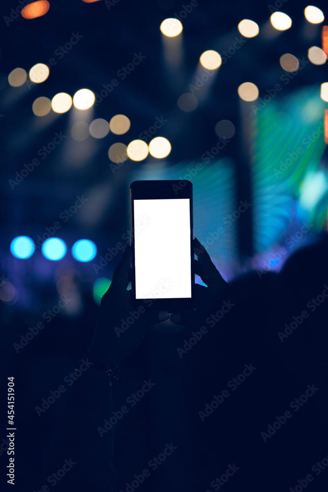 Person holding modern smartphone on a concert.