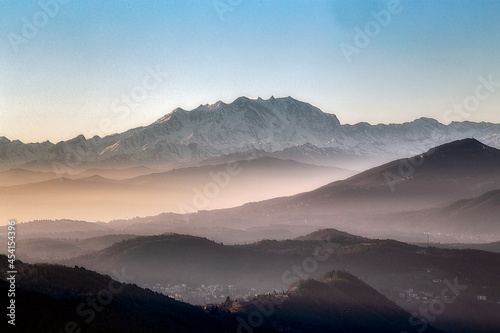 View of the misty and fog surrounding the mountains of the Italian Alps at winter sunset.  Layers of mountains. Nature tourism. © Fernando Calmon
