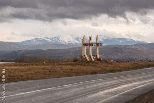 Sayanogorsk, Khakassia, Russia - a road sign-monument stella at the entrance to the city. Soviet vintage road decoration. Translation: Sayanogorsk photo