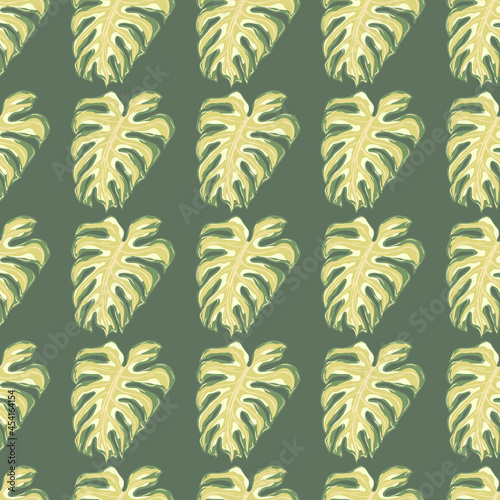 Beige colored monstera leaves seamless pattern in pale tones. Grey background. Abstract nature print.