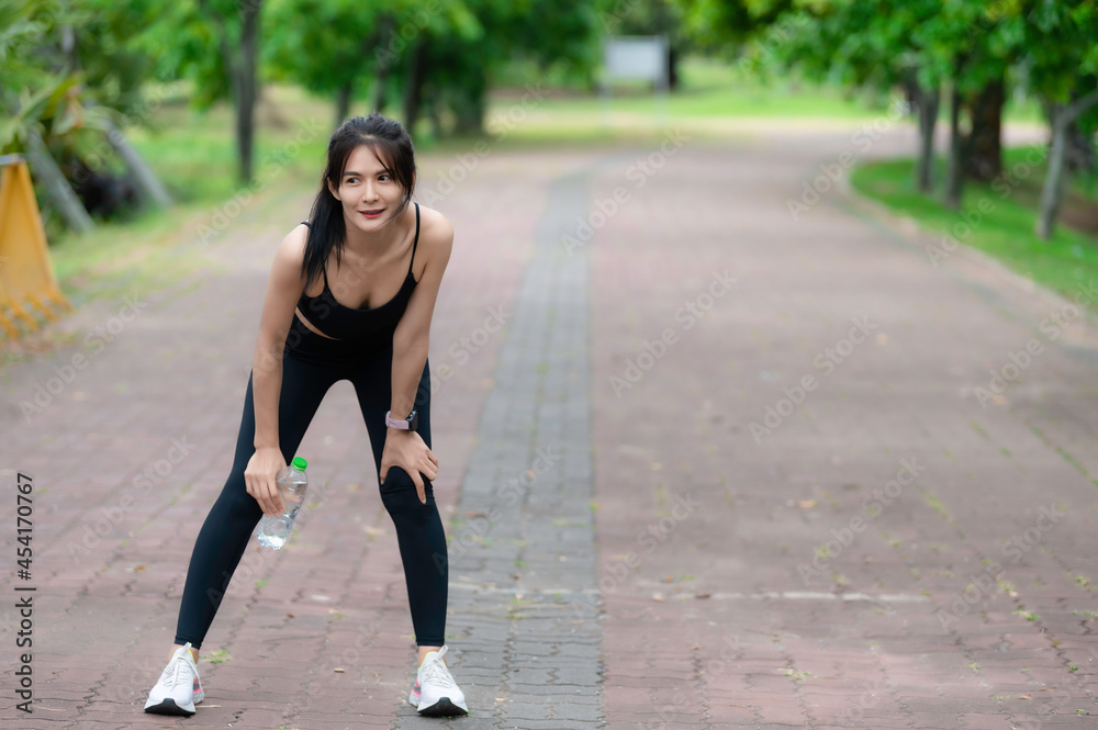Asian slim woman exercise alone in the park,Tired from workout Asian slim woman exercise alone in the park,Tired from workout