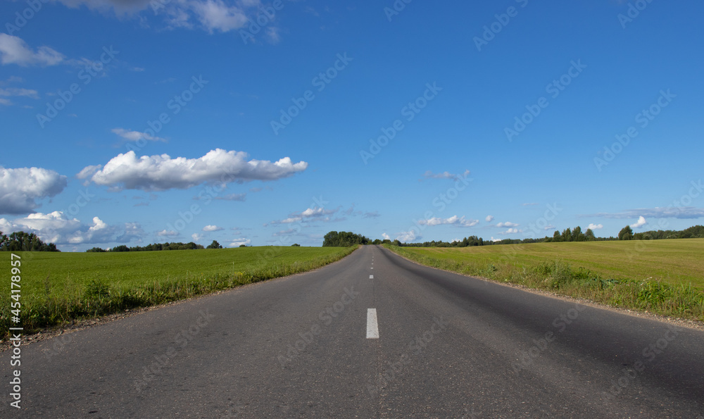 landscape of an empty paved road and a blue sky