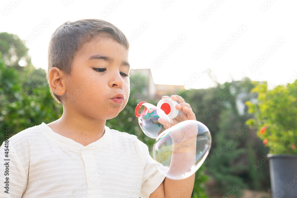Little boy blowing bubbles in garden Little boy blowing bubbles in garden