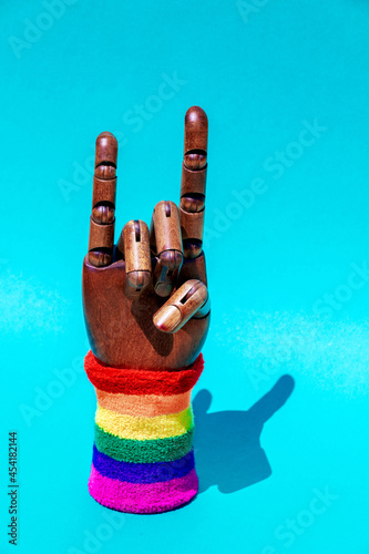 Hand with horn gesture and LGBTQ ornament on wristband