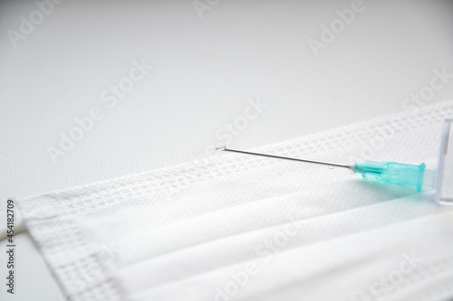 Mask. Syringe and needle. White background. Drop