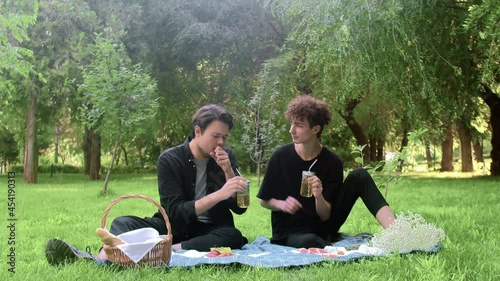 The guy choked on a drink, and the guy next to him patted him on the back in the summer in nature