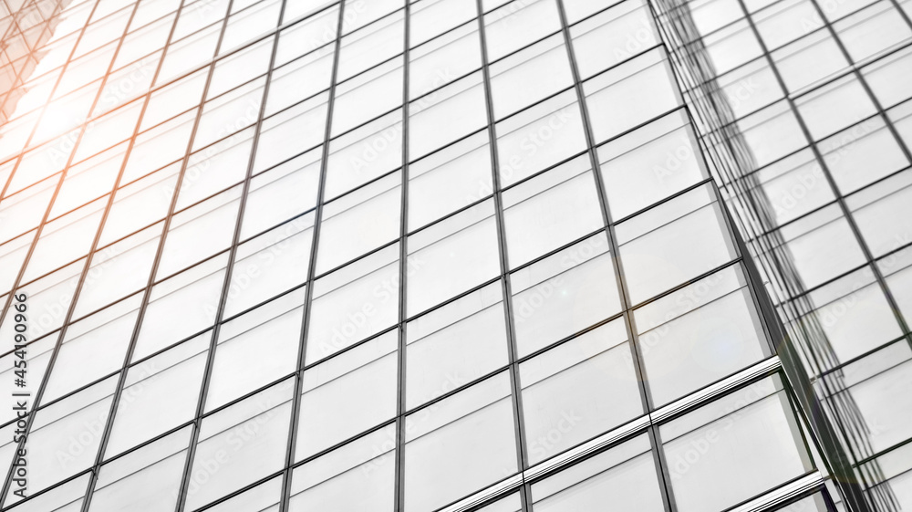 Modern architectural details. Modern glass facade with a geometric pattern. Contemporary corporate business architecture. Red sun on horizon. Black and white toned image. Modern architectural details. Modern glass facade with a geometric pattern. Contemporary corporate business architecture. Red sun on horizon. Black and white toned image.