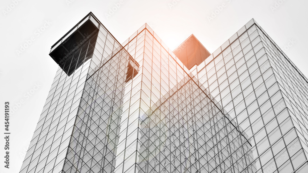 Modern architectural details. Modern glass facade with a geometric pattern. Contemporary corporate business architecture. Red sun on horizon. Black and white toned image. Modern architectural details. Modern glass facade with a geometric pattern. Contemporary corporate business architecture. Red sun on horizon. Black and white toned image.