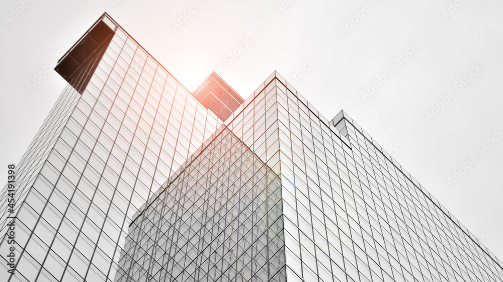 Modern architectural details. Modern glass facade with a geometric pattern. Contemporary corporate business architecture. Red sun on horizon. Black and white toned image. Modern architectural details. Modern glass facade with a geometric pattern. Contemporary corporate business architecture. Red sun on horizon. Black and white toned image.