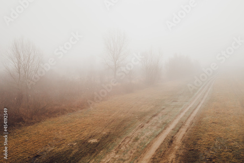 Countryside dirt road in foggy winter morning