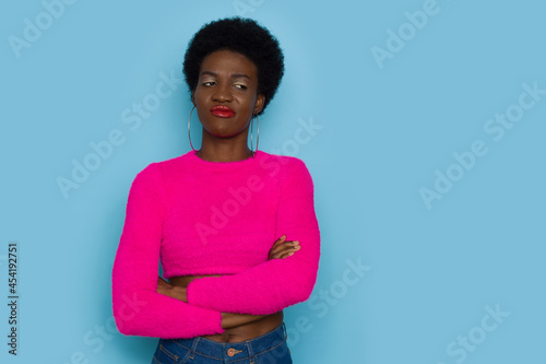 Fotografija Grimacing Young Black Woman In Pink Sweater Looking To The Side