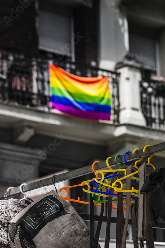 LGTBI+ pride flag in the background and hangers with the same colors in the street