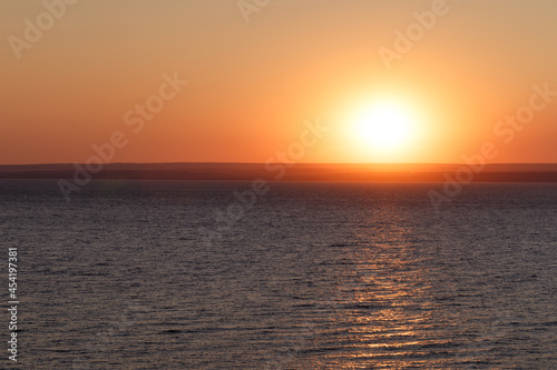 Beautiful colorful sunset over the sea. The red sun and the absence of clouds. Sea horizon. Aerial view. Landscape. The concept of a postcard picture. Light waves on the sea surface © svetlichniy_igor