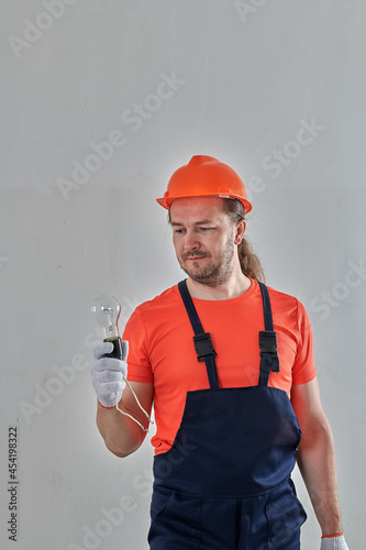 a light bulb in the hands of a professional electrician