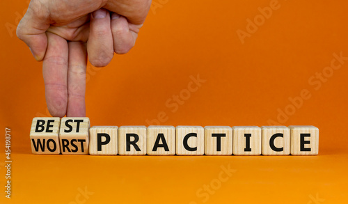 Best or worst practice symbol. Businessman turns wooden cubes and changes words 'worst practice' to 'best practice'. Beautiful orange background. Business, best or worst practice concept. Copy space. photo