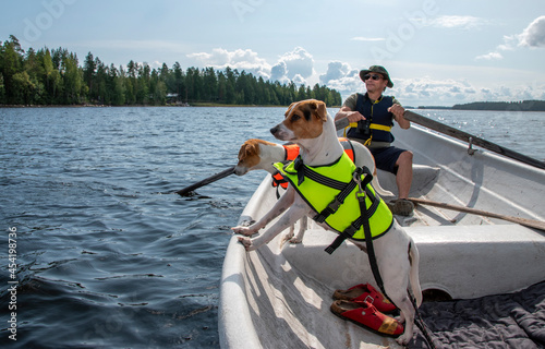 Man rowing on a lake in a rowing boat with dogs