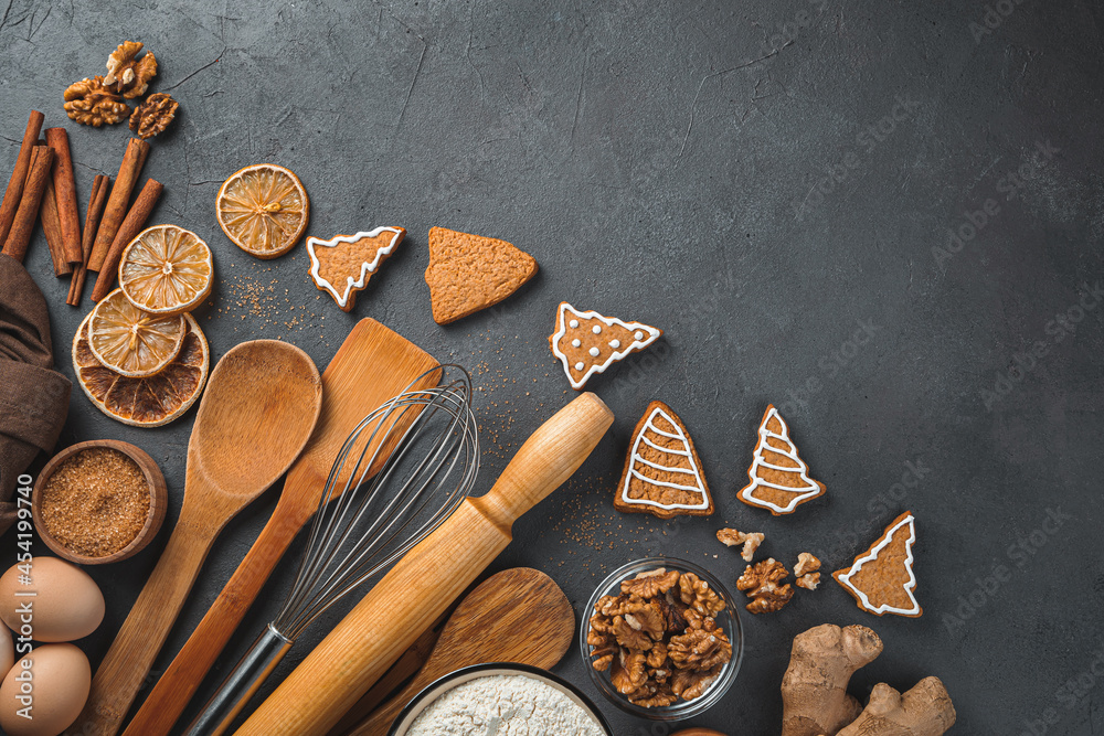 Festive culinary background. Ingredients, ginger cookies and cooking utensils on a brown background. Copy space Festive culinary background. Ingredients, ginger cookies and cooking utensils on a brown background. Copy space