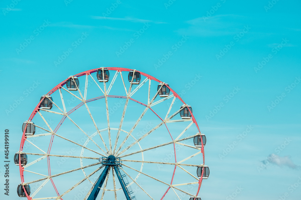 Ferris wheel against the background of the cloudy sky. Close-up photo Ferris wheel against the background of the cloudy sky. Close-up photo
