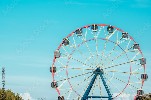 Ferris wheel against the background of the cloudy sky. Close-up photo