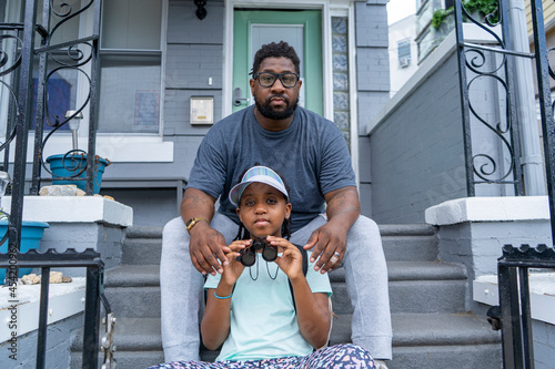 Portrait of father and daughter sitting on porch
