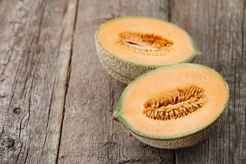 Halves of cantaloupe melon on old wooden planks