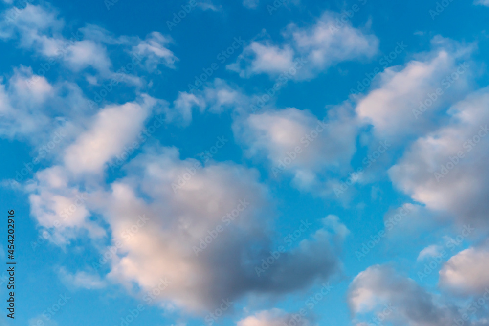 Naklejka premium Blue sky with many small cumulus clouds illuminated by the sun as a natural background