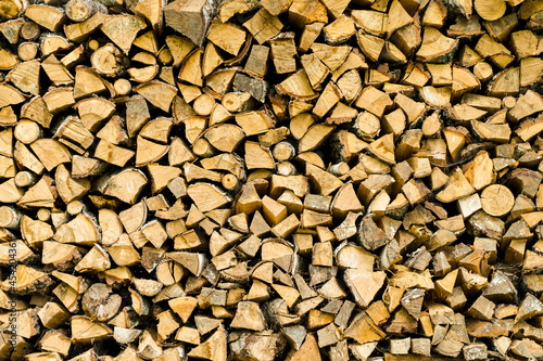 Firewood background in the backyard of a village house. Firewood masonry for heating or lighting a fire in the countryside