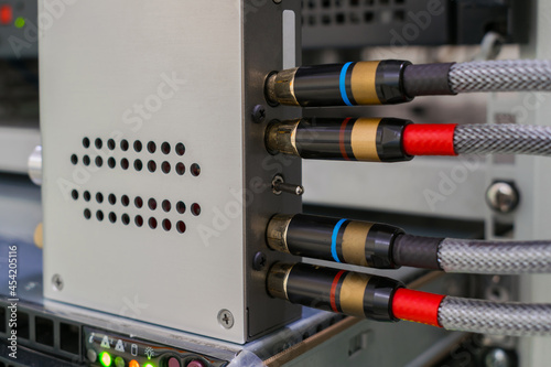 The AV cables are connected to a digital amplifier. The digital signal converter is in the rack. The multimedia equipment works in the server room. photo